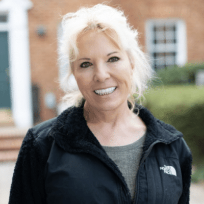 A female smile rehabilitation patient outside and smiling, representing dental implants in fredericksburg va