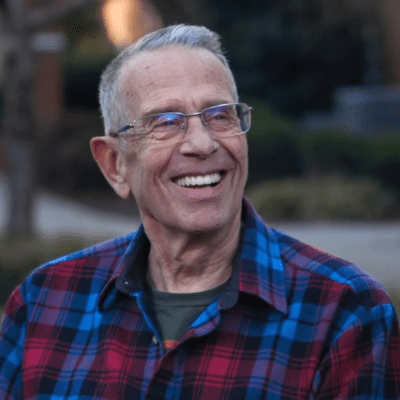 Man in plaid shirt outdoors smiling, representing what to eat after dental implant surgery